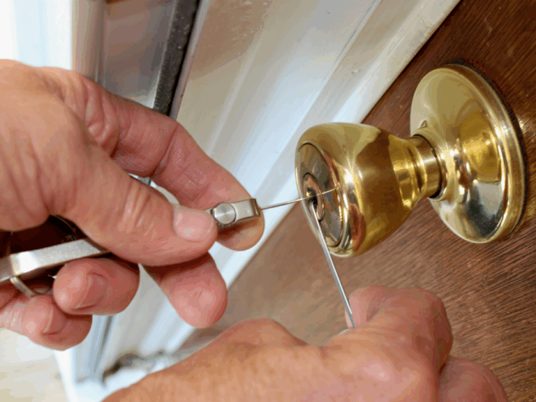 Close-up of a locksmith removing a broken key from a front door lock.